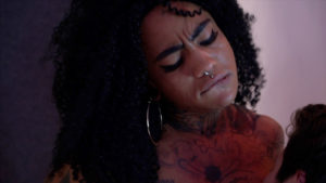 photo of the glamorous Cherie's face, biting their lip.
