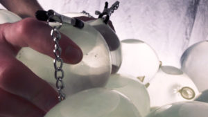 image of someone holding clear balloons with a chain and clamps.