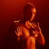 Still image from the short film, Progressive Touch of a dancing naked woman with her hair slicked back. 